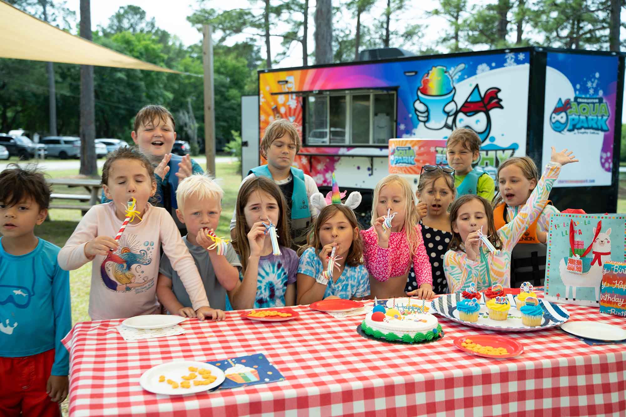 Bunch of happy kids staying in front of a table with cake